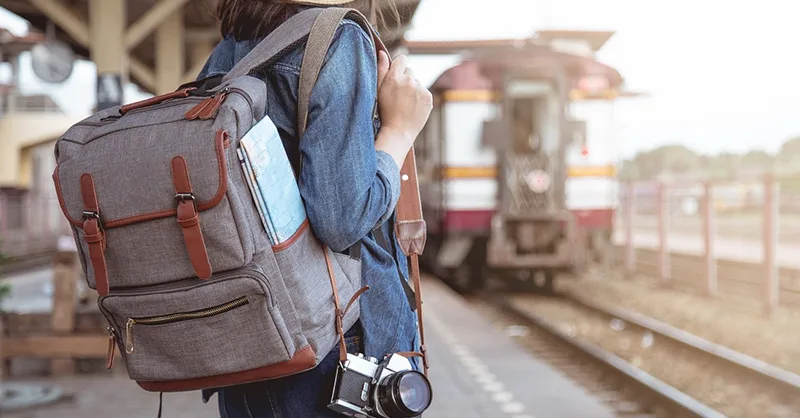 Image, photo d'une personne, une femme tenant un sac à dos avec une carte, un appareil photo.
