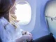 Voyager en avion : image, photo d'une personne, une femme bien confortable dans un avion.