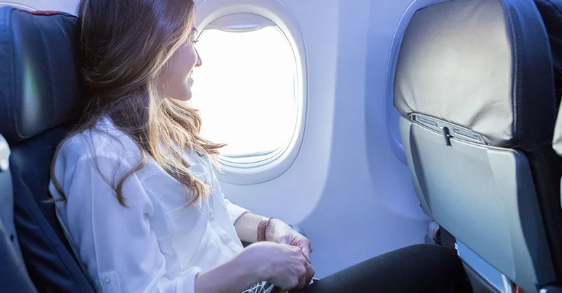 Voyager en avion : image, photo d'une personne, une femme bien confortable dans un avion.