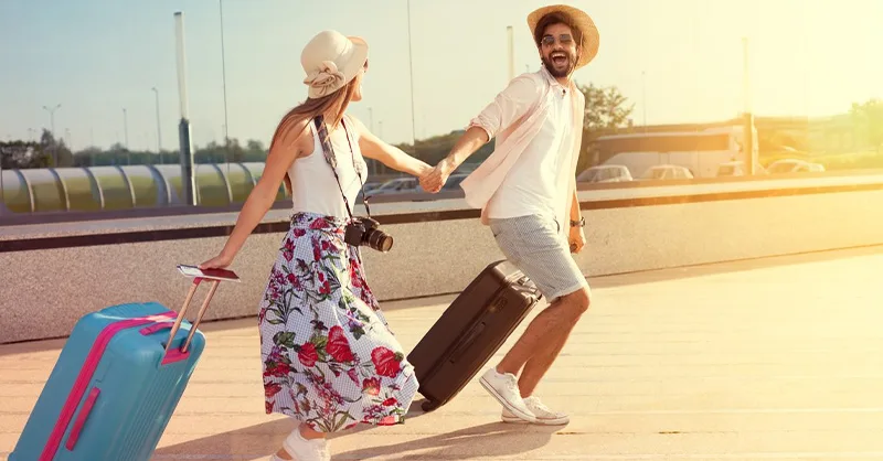 Voyage en amoureux : image, photo d'un coupe main dans la main, marchant au coucher du soleil avec leurs valises
